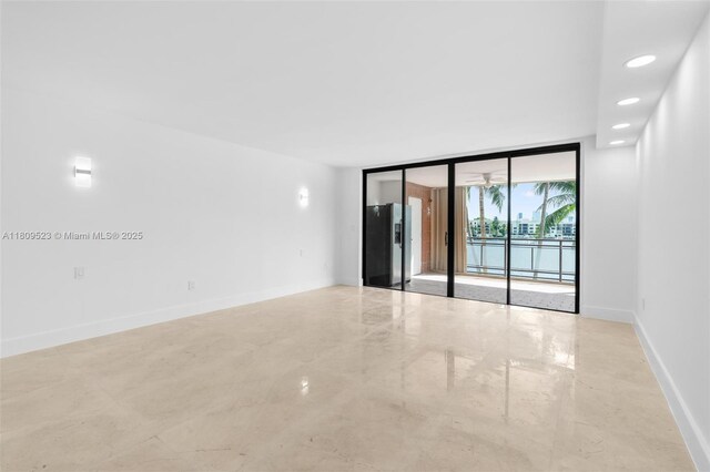2300 Diana Dr Unit 302, Hallandale Beach, FL 33009 - spare room with a wall of windows, concrete floors, and baseboards