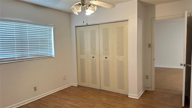 550 NW 80th Ter Unit 103, Margate, FL 33063 - unfurnished bedroom featuring wood finished floors, a closet, baseboards, a textured ceiling, and ceiling fan