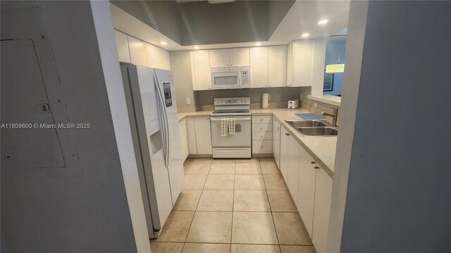 17375 Collins Ave Unit 2606, Sunny Isles Beach, FL 33160 - kitchen featuring white appliances, a sink, light countertops, light tile patterned floors, and white cabinets