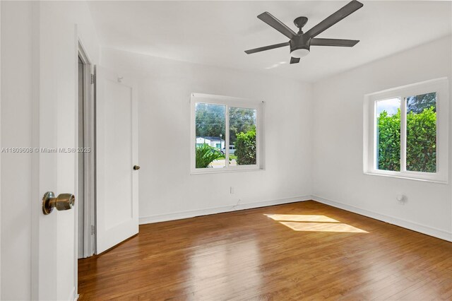 152 NW 103rd St, Miami Shores, FL 33150 - empty room with wood finished floors, a ceiling fan, and baseboards