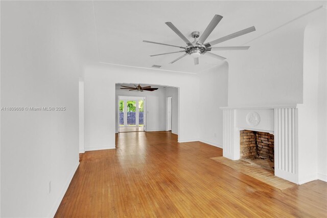 152 NW 103rd St, Miami Shores, FL 33150 - unfurnished living room with light wood-type flooring, a ceiling fan, baseboards, and a fireplace with flush hearth