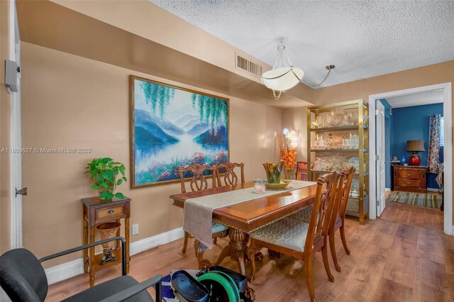 203 E Capri Unit E, Delray Beach, FL 33484 - dining room with wood finished floors, a textured ceiling, and baseboards