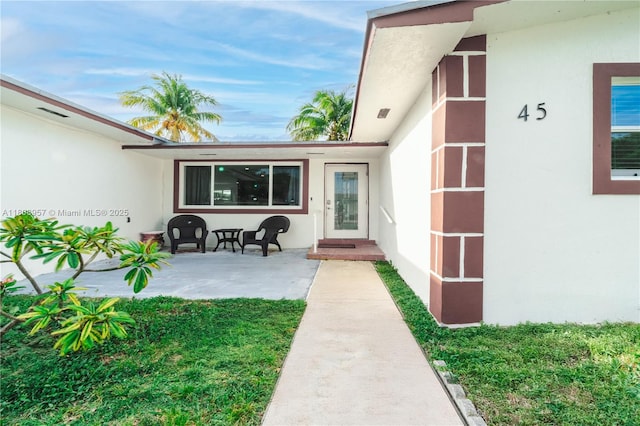 45 NW 188th St, Miami Gardens, FL 33169 - doorway to property with stucco siding and a patio