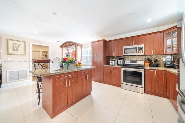 45 NW 188th St, Miami Gardens, FL 33169 - kitchen with stainless steel appliances, a kitchen bar, decorative backsplash, a center island, and glass insert cabinets