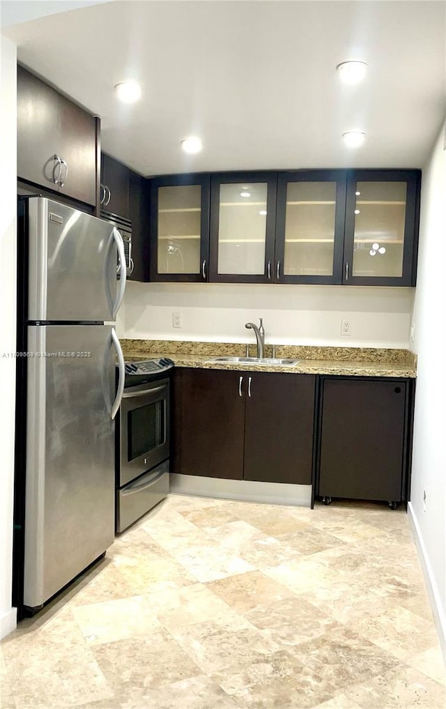3025 Mary St Unit 5, Miami, FL 33133 - kitchen with stainless steel appliances, a sink, glass insert cabinets, and light stone counters