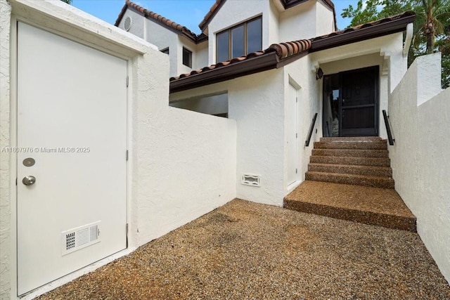 7932 Seville Pl Unit 2104, Boca Raton, FL 33433 - view of exterior entry with stucco siding and a tiled roof