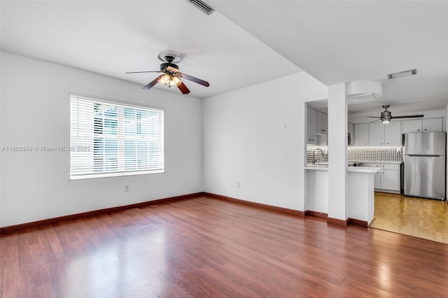 1051 Meridian Ave Unit 1-A, Miami Beach, FL 33139 - unfurnished living room featuring ceiling fan, wood finished floors, and baseboards