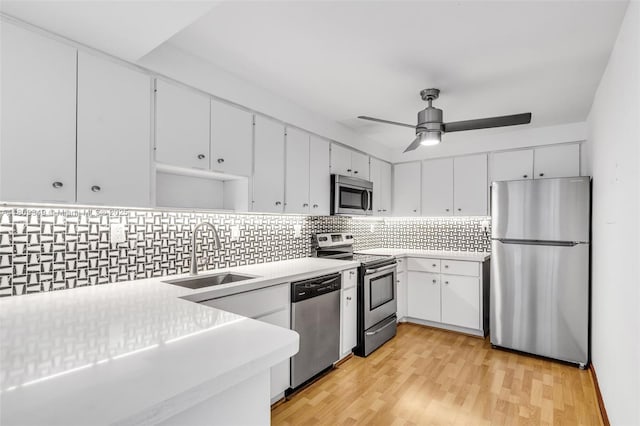 1051 Meridian Ave Unit 1-A, Miami Beach, FL 33139 - kitchen with stainless steel appliances, a sink, light countertops, tasteful backsplash, and light wood-style floors
