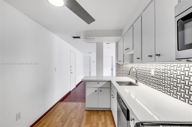 1051 Meridian Ave Unit 1-A, Miami Beach, FL 33139 - kitchen featuring a sink, appliances with stainless steel finishes, backsplash, a peninsula, and light countertops
