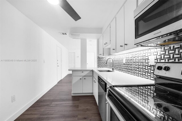 1051 Meridian Ave Unit 1-A, Miami Beach, FL 33139 - kitchen with stainless steel appliances, light countertops, white cabinetry, tasteful backsplash, and a peninsula