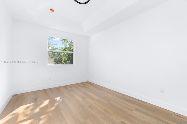 1470 SE 26th Ave, Homestead, FL 33035 - unfurnished room with baseboards, light wood-style floors, and a tray ceiling