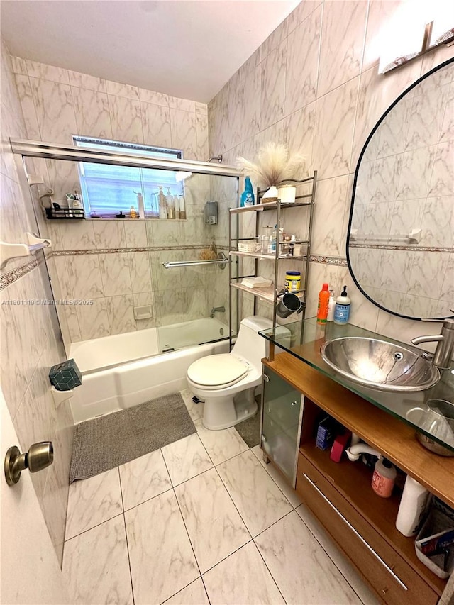 21000 NE 26th Ave, Miami, FL 33180 - bathroom with combined bath / shower with glass door, toilet, vanity, marble look tile flooring, and tile walls