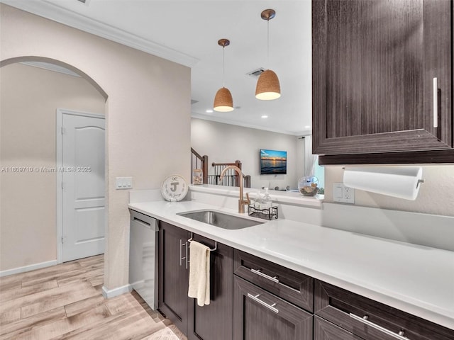 5907 Monterra Club Dr, Lake Worth, FL 33463 - kitchen with a sink, dark brown cabinetry, arched walkways, stainless steel dishwasher, and ornamental molding
