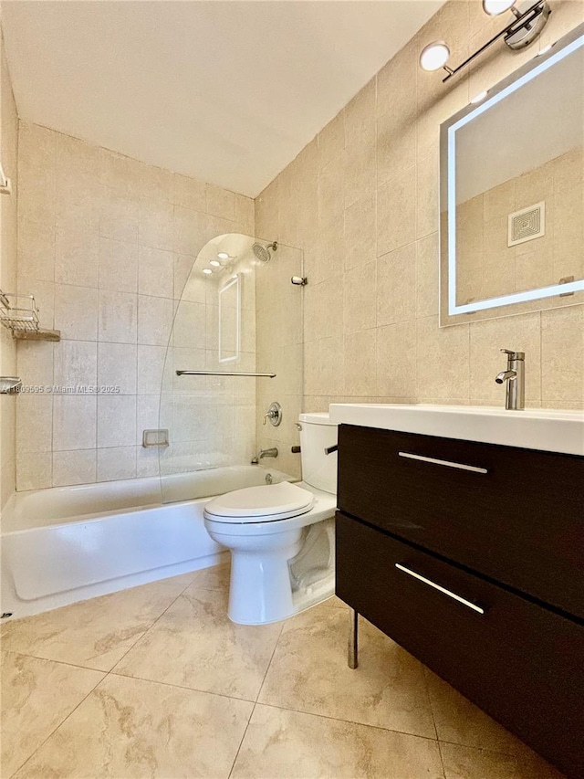 3536 NE 168th St Unit 201, North Miami Beach, FL 33160 - full bathroom with vanity, washtub / shower combination, toilet, tile walls, and tile patterned floors