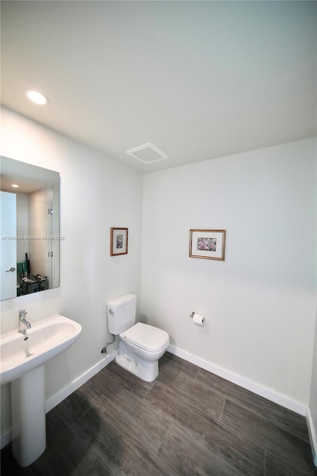 2900 NE 7th Ave Unit 2105, Miami, FL 33137 - half bathroom featuring toilet, wood finished floors, baseboards, a sink, and recessed lighting