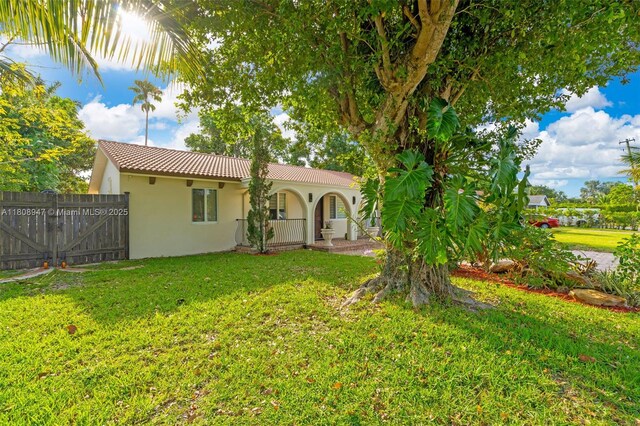 641 SW 50th Ave, Margate, FL 33068 - rear view of property featuring stucco siding, a tiled roof, and a porch