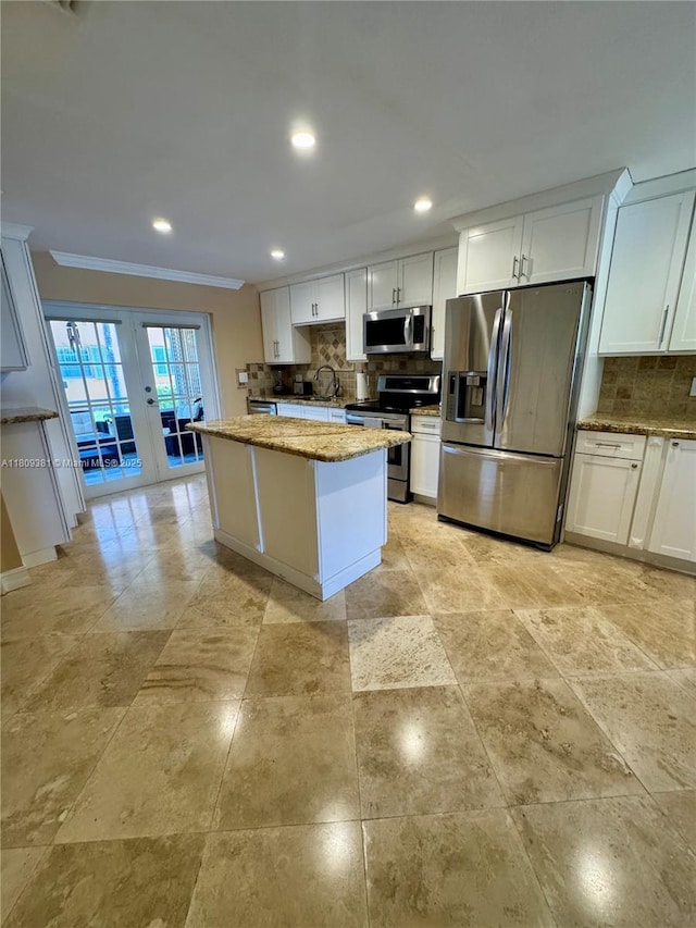 2200 Monroe St Unit 33, Hollywood, FL 33020 - kitchen featuring stainless steel appliances, ornamental molding, tasteful backsplash, a center island, and a sink
