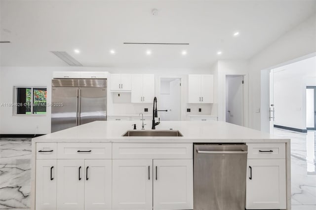 5121 SW 210th Ter, Southwest Ranches, FL 33332 - kitchen with appliances with stainless steel finishes, a sink, light marble finish flooring, white cabinets, and a center island with sink