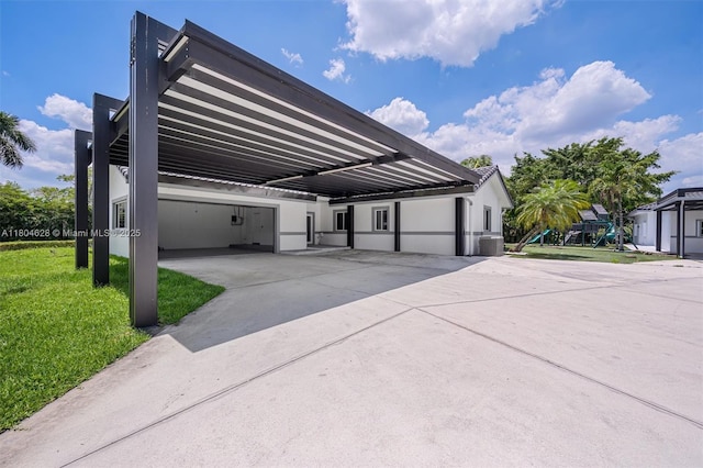 5121 SW 210th Ter, Southwest Ranches, FL 33332 - view of side of home with stucco siding, a lawn, a carport, and a playground
