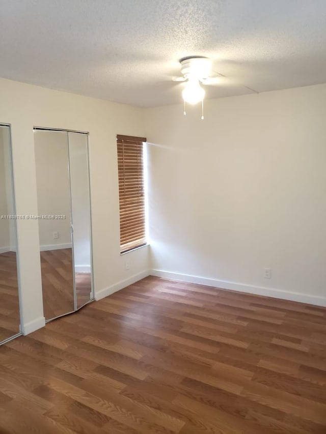 9909 Twin Lakes Dr Unit 26-F, Coral Springs, FL 33071 - unfurnished bedroom featuring multiple closets, wood finished floors, a ceiling fan, baseboards, and a textured ceiling