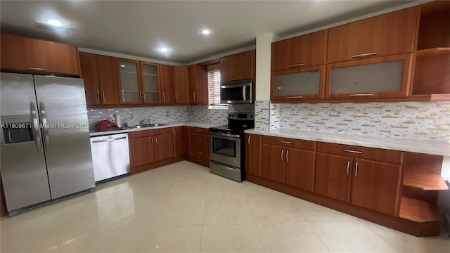 421 NE 1st St Unit 119, Hallandale Beach, FL 33009 - kitchen featuring stainless steel appliances, a sink, backsplash, brown cabinetry, and open shelves