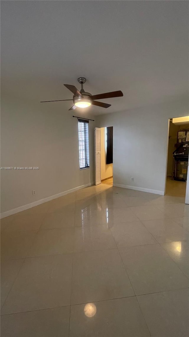 421 NE 1st St Unit 119, Hallandale Beach, FL 33009 - empty room with light tile patterned floors, a ceiling fan, and baseboards