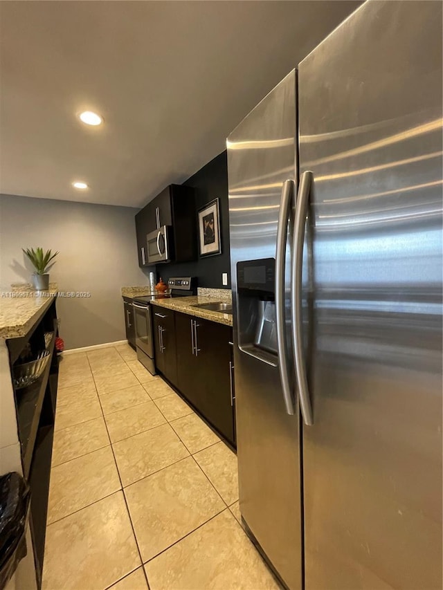 421 NE 1st St Unit 119, Hallandale Beach, FL 33009 - kitchen featuring stainless steel appliances, recessed lighting, light tile patterned floors, a sink, and dark cabinets