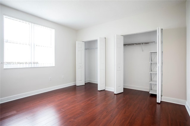 50 SW Menores Ave Unit 732, Coral Gables, FL 33134 - unfurnished bedroom with multiple closets, dark wood-style flooring, and baseboards