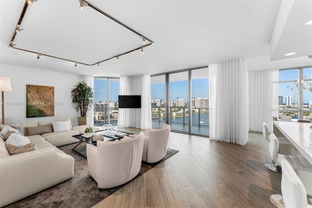 17301 Biscayne Blvd Unit 2210, North Miami Beach, FL 33160 - living room featuring floor to ceiling windows, rail lighting, wood finished floors, and a chandelier