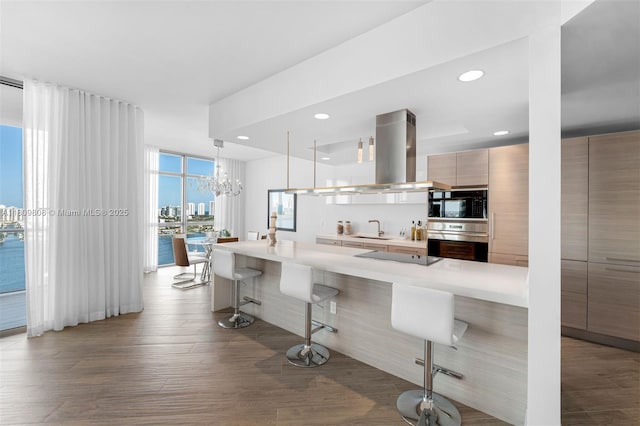 17301 Biscayne Blvd Unit 2210, North Miami Beach, FL 33160 - kitchen featuring black appliances, modern cabinets, a kitchen bar, light countertops, and a sink