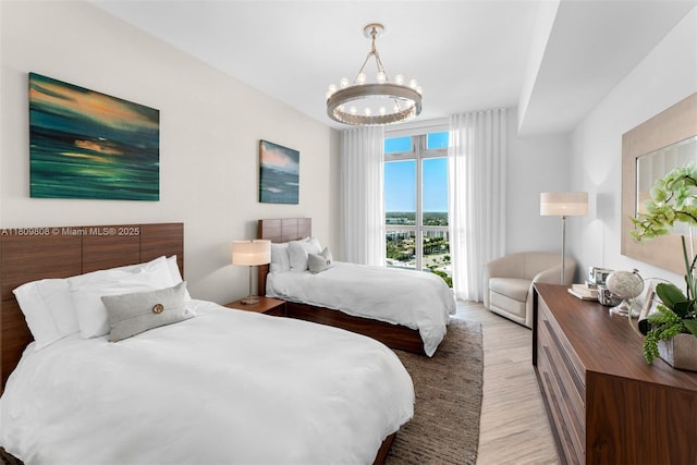 17301 Biscayne Blvd Unit 2210, North Miami Beach, FL 33160 - bedroom featuring a chandelier and light wood-style flooring