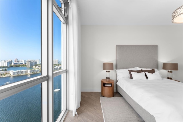 17301 Biscayne Blvd Unit 2210, North Miami Beach, FL 33160 - bedroom featuring wood finished floors, a water view, baseboards, and a view of city