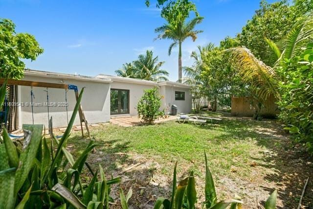 1240 NE 176th St, North Miami Beach, FL 33162 - back of house featuring a yard and stucco siding