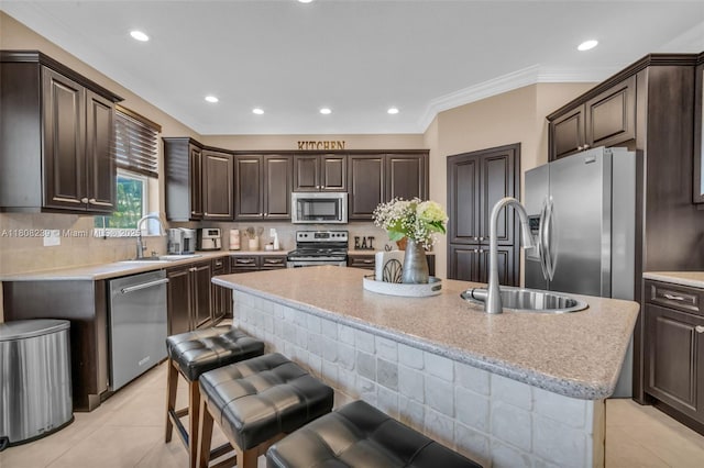 9003 Alexandra Cir, Wellington, FL 33414 - kitchen featuring appliances with stainless steel finishes, a sink, a kitchen island, dark brown cabinets, and ornamental molding