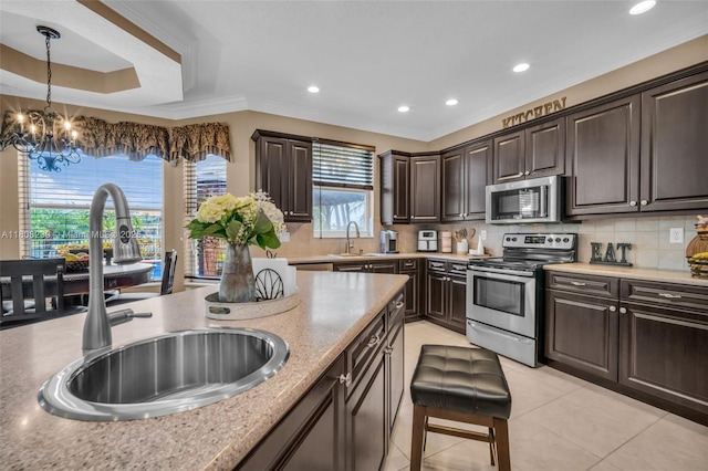 9003 Alexandra Cir, Wellington, FL 33414 - kitchen featuring stainless steel appliances, a sink, dark brown cabinets, recessed lighting, and tasteful backsplash