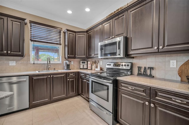 9003 Alexandra Cir, Wellington, FL 33414 - kitchen with appliances with stainless steel finishes, a sink, light tile patterned floors, dark brown cabinetry, and light countertops