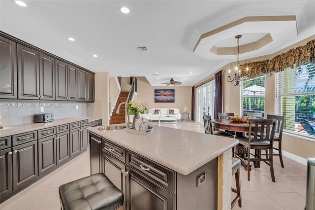 9003 Alexandra Cir, Wellington, FL 33414 - kitchen with light tile patterned floors, a chandelier, a kitchen island with sink, recessed lighting, and decorative backsplash