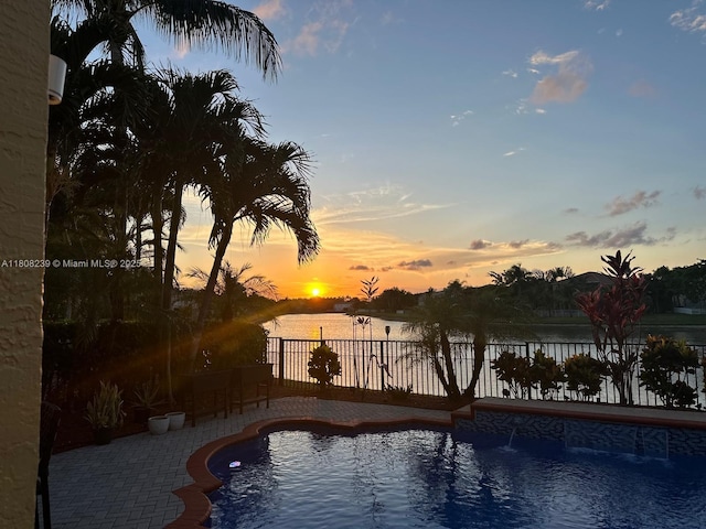 9003 Alexandra Cir, Wellington, FL 33414 - pool at dusk with a fenced backyard, a water view, and a patio area