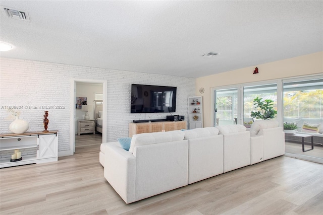 5920 SW 94th Ave, Miami, FL 33173 - living room with a textured ceiling, light wood finished floors, and brick wall