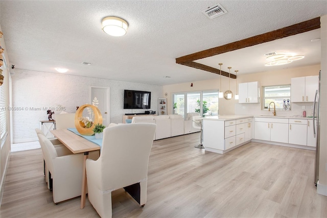 5920 SW 94th Ave, Miami, FL 33173 - dining space with a textured ceiling, light wood-style flooring, and brick wall