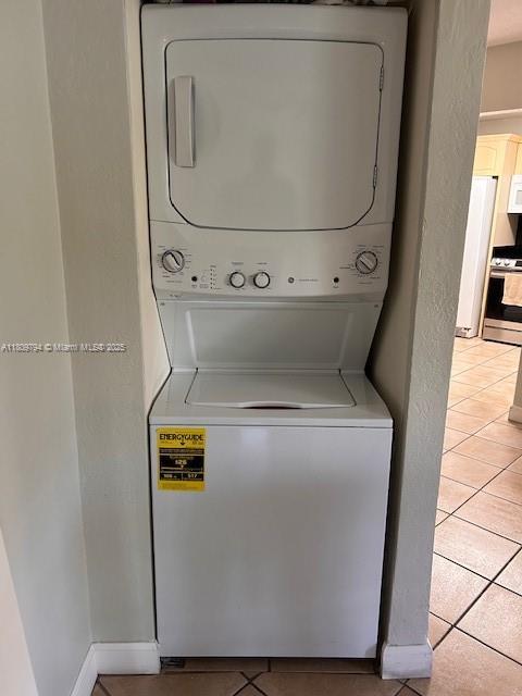 11201 NW 7th St Unit 204, Sweetwater, FL 33172 - washroom featuring stacked washing machine and dryer and light tile patterned floors
