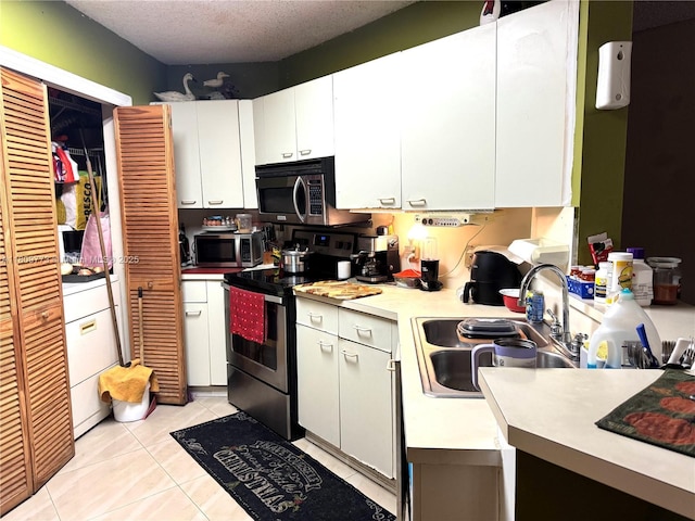 6276 NW 186th St Unit 305, Hialeah, FL 33015 - kitchen with appliances with stainless steel finishes, a sink, white cabinets, light tile patterned floors, and light countertops