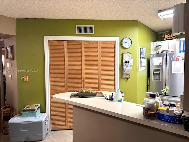6276 NW 186th St Unit 305, Hialeah, FL 33015 - kitchen featuring stainless steel fridge with ice dispenser, a textured ceiling, light tile patterned flooring, and light countertops