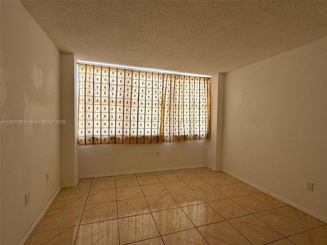 1301 NE Miami Gardens Dr Unit 1025W, Miami, FL 33179 - empty room featuring a textured ceiling and tile patterned floors