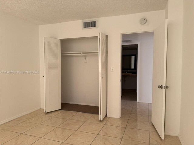 1301 NE Miami Gardens Dr Unit 1025W, Miami, FL 33179 - unfurnished bedroom with a closet, a textured ceiling, and baseboards