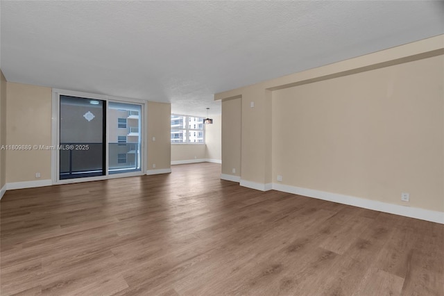 1904 S Ocean Dr Unit 1004, Hallandale Beach, FL 33009 - unfurnished living room with wood finished floors, baseboards, and a textured ceiling