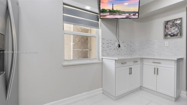 3910 Inverrary Blvd Unit 101-B, Lauderhill, FL 33319 - detailed view of stainless steel refrigerator with ice dispenser, backsplash, and baseboards