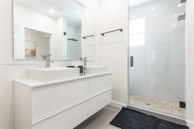 168 NE 47th St, Miami, FL 33137 - bathroom featuring a shower stall, double vanity, wood finished floors, and baseboards