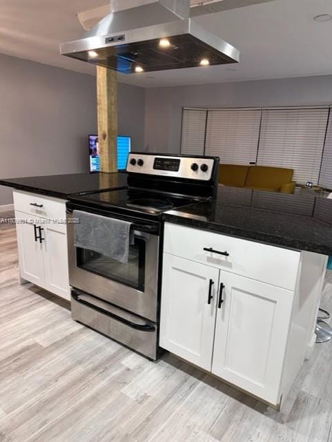2359 Gabriel Ln, West Palm Beach, FL 33406 - kitchen featuring stainless steel electric range oven, wall chimney exhaust hood, light wood-style floors, white cabinets, and a peninsula