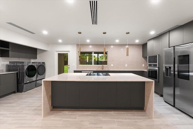 11505 NE 11th Pl, Biscayne Park, FL 33161 - kitchen featuring separate washer and dryer, appliances with stainless steel finishes, a spacious island, a sink, and modern cabinets